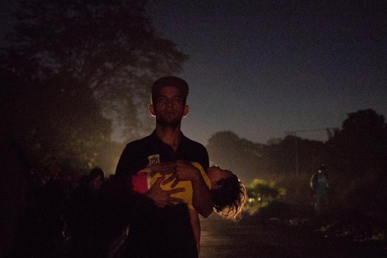 Anh Christian bế cô con gái 1 tuổi, bé Marcella, trên đường từ Tapachula, Mexico, tới Huixtla, trong đêm tối 31/10.