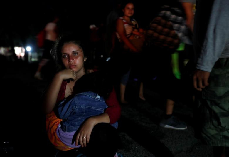 Solmy Rosales bế con của cô, bé Anahi Rosales, 2 tuổi, ngồi nghỉ gần Huixtla, Mexico, trên đường vượt biên vào Mỹ ngày 2/11/2018.