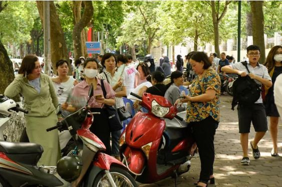 Trời nắng nóng, nhiều phụ huynh chọn chỗ râm mát để chờ thí sinh. (Ảnh: Gia Đình và Xã Hội)