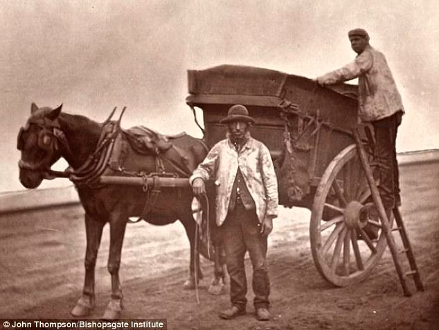 Hai người đàn ông bên chiếc xe ngựa chuyên chở hàng hóa.