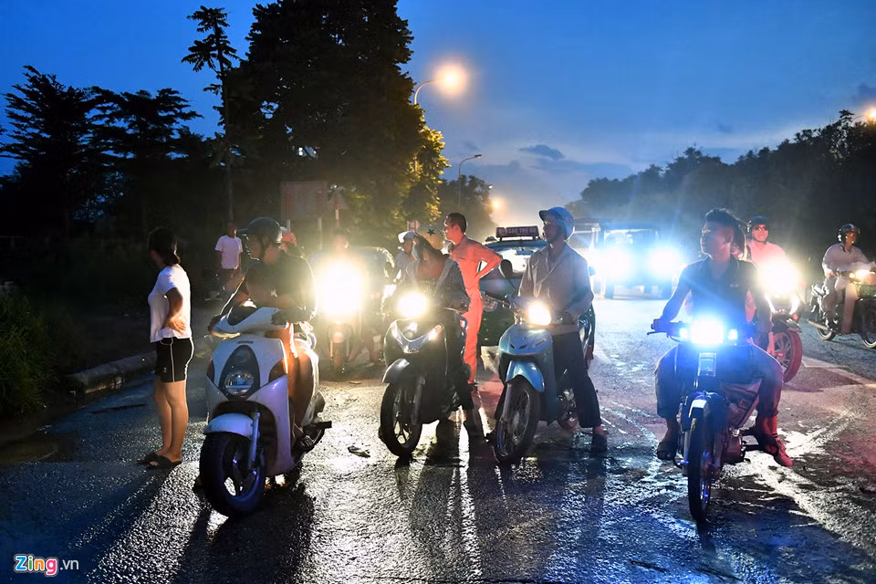 Trước vị trí bị ngập, nhiều người đi xe máy dừng lại nghe ngóng, quan sát người đi trước qua các lối nhỏ đi tắt vào khu đô thị Nam An Khánh.