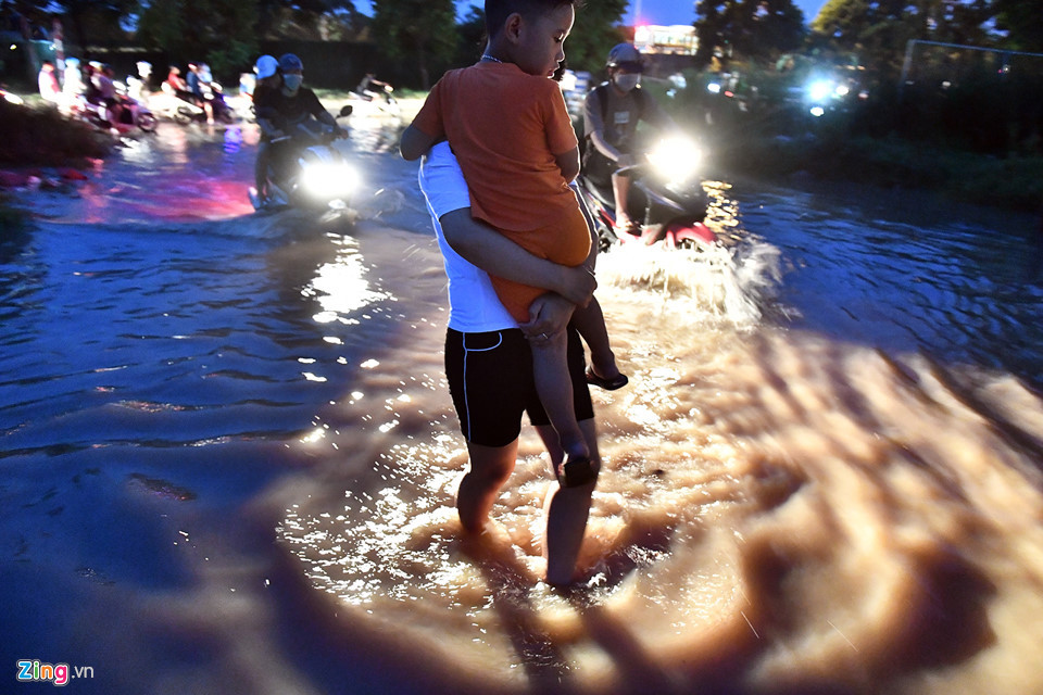 Chị Huyền, cư dân ở khu đô thị này vừa bế con vừa than hệ thống thoát nước ở khu vực này quá kém. "Lần nào ngập cũng mấy ngày sau mới rút", chị xuống xe đi bộ vào nhà từ đường gom đại lộ Thăng Long.