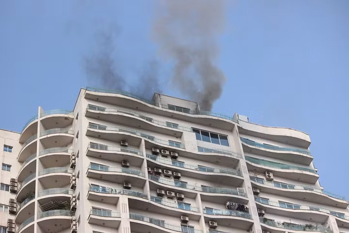 Khói đen bốc lên từ tầng cao nhất của chung cư.