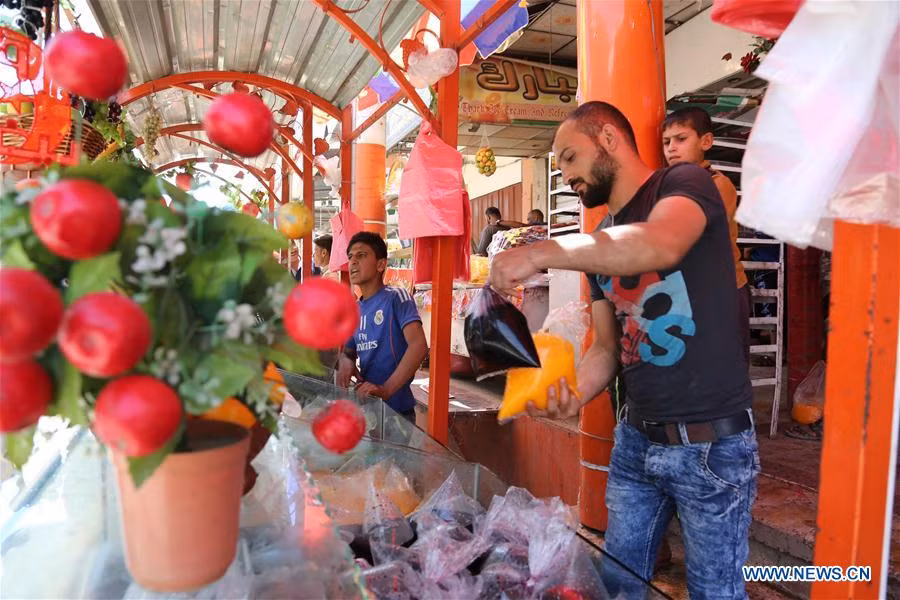 Người bán hàng Iraq đặt những túi nước ép trái cây vào tủ. Ảnh: THX.