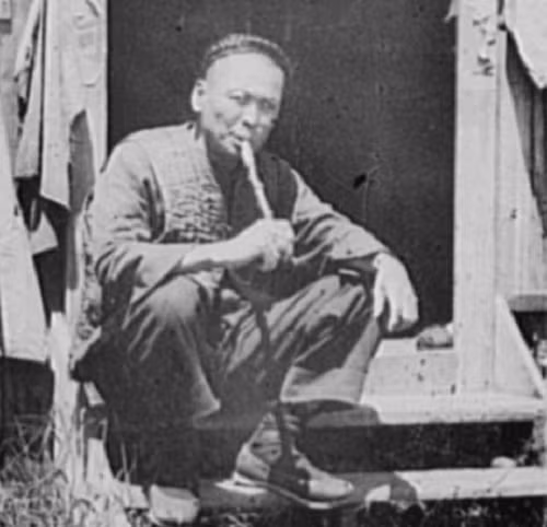 Một cư dân ngồi bên ngoài nhà trong khu Phố Tàu hàng trăm năm trước.