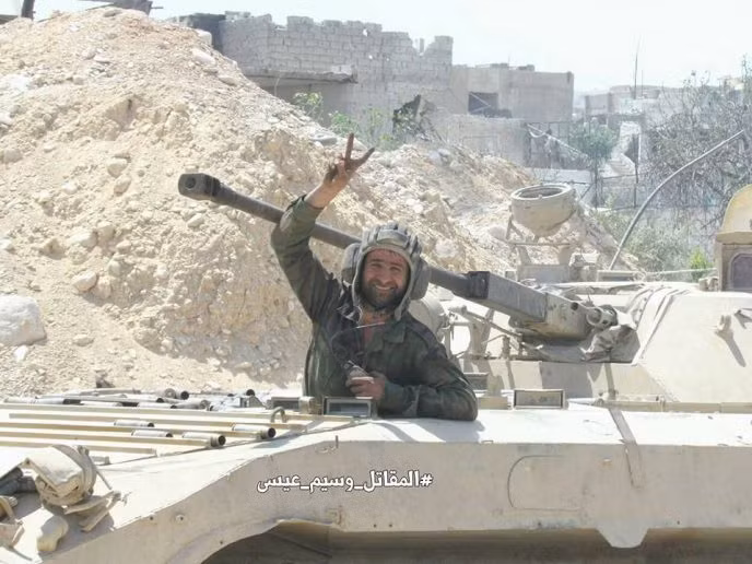 Một binh sĩ Syria giơ tay biểu tượng chiến thắng khi tham gia vào chiến dịch quân sự chống khủng bố ở Al-Qaboun. Ảnh: AMN.