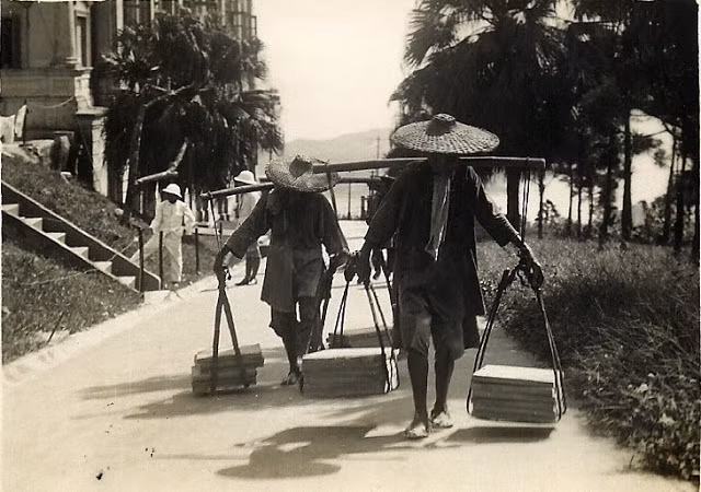 Người dân gánh gồng đi trên một con đường ở Hong Kong. Ảnh: VT.