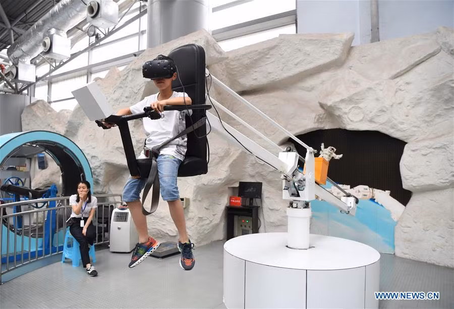 Bé Zhou Zimu, 11 tuổi, đeo kính thực tế ảo và chơi trò chơi tại Viện bảo tàng Khoa học và Công nghệ ở Trùng Khánh ngày 30/4. Ảnh: THX.