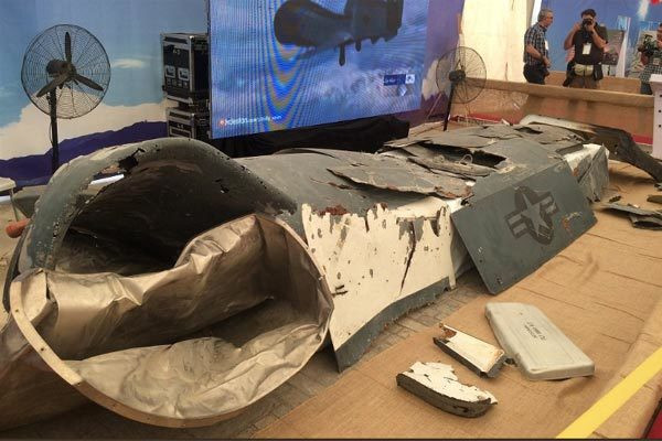 Các mảnh vỡ và một vài mẫu UAV gần như còn nguyên vẹn tại triển lãm của Iran. Ảnh: IWN