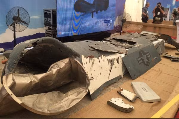 Các mảnh vỡ và một vài mẫu UAV gần như còn nguyên vẹn tại triển lãm của Iran. Ảnh: IWN