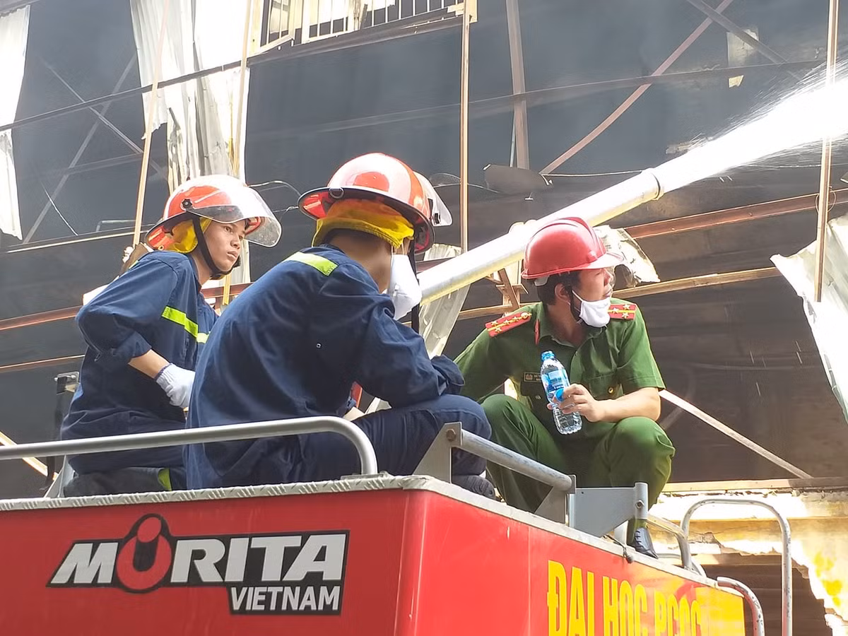 Lực lượng PCCC được sự hỗ trợ của công an khu vực đang tích cực xử lý đám cháy.