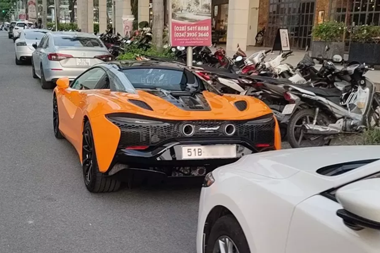 Hai chiếc siêu xe mui trần McLaren Artura Spider xuất hiện trước đó có màu tím và đen, còn xe này có màu cam với điểm nhấn là bộ mâm đa chấu và nhiều chi tiết ở ngoại thất sơn đen.