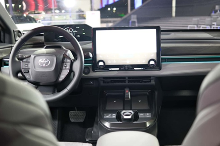 Vô lăng chắc chắn và bảng điều khiển trung tâm gọn gàng. Đối với C-HR+, cần số xoay và các nút đi kèm được đặt xa hơn so với bZ4X, cho phép 2 bộ sạc không dây chiếm không gian bên dưới các lỗ thông gió trung tâm.