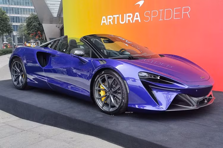Chiếc siêu xe McLaren Artura Spider trong bài sở hữu màu sơn ngoại thất tím trẻ trung, hiện đại. Artura Spider vẫn sử dụng cấu trúc khung gầm nhôm và carbon như bản Coupe (mui cứng), nhưng cải thiện độ cứng đồng thời giảm trọng lượng của bộ phận này đi khoảng 62 kg so với bản Coupe dù sở hữu cơ cấu đóng/mở mui xe bằng điện.