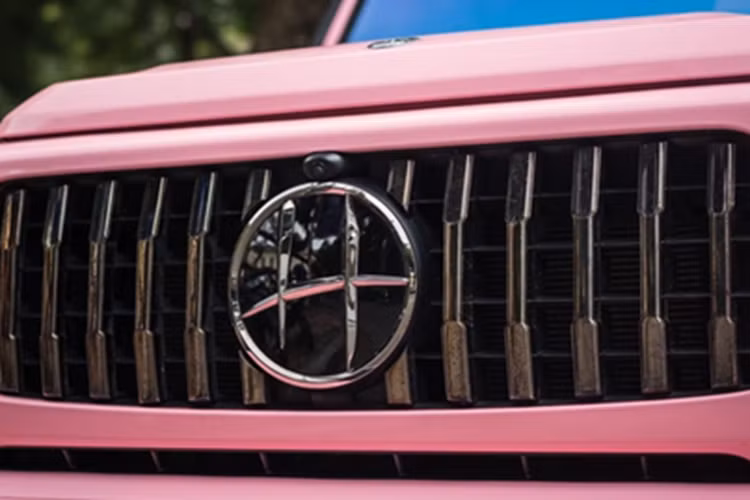 Xuất hiện trên con phố Kim Mã, phường Kim Mã, quận Ba Đình, Hà Nội, chiếc SUV hạng sang Mercedes-AMG G63 này nhanh chóng thu hút sự quan tâm với ngoại thất mang màu hồng, đi kèm đó là nhiều chi tiết được sơn đen.