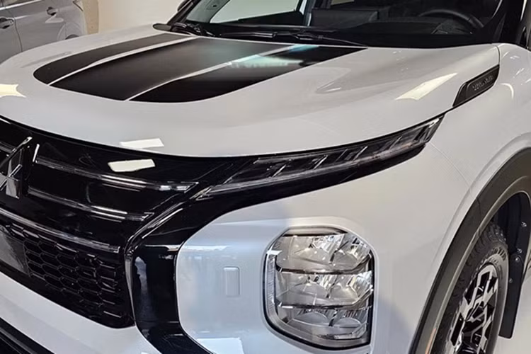 Nhiều chi tiết ngoại thất của mẫu xe SUV Mitsubishi Outlander Trail Edition này được sơn tối màu, tương tự biến thể Black Edition đang được phân phối tại Mỹ. Nắp capo cũng được dán các họa tiết màu đen.