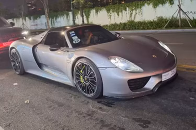 Porsche 918 Spyder trong bài viết này có màu sơn xám, 2 phần mui xe có thể tháo rời bằng carbon, khi mái nhà được tháo xuống, người dùng có thể cất gọn vào trong khoang hành lý phía trước của chiếc xe Porsche 918 Spyder.