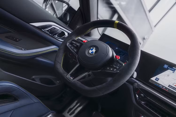 Nội thất của M4 CS Edition VR46 với ghế M Carbon bọc da Merino màu Đen/Xanh Đêm - Black/Night Blue Merino, điểm nhấn bằng chất liệu Alcantara màu vàng - Sao Paulo Yellow ở phần vai, cùng đường chỉ khâu vàng trên vô lăng và một dấu mốc vàng tại vị trí 12 giờ.