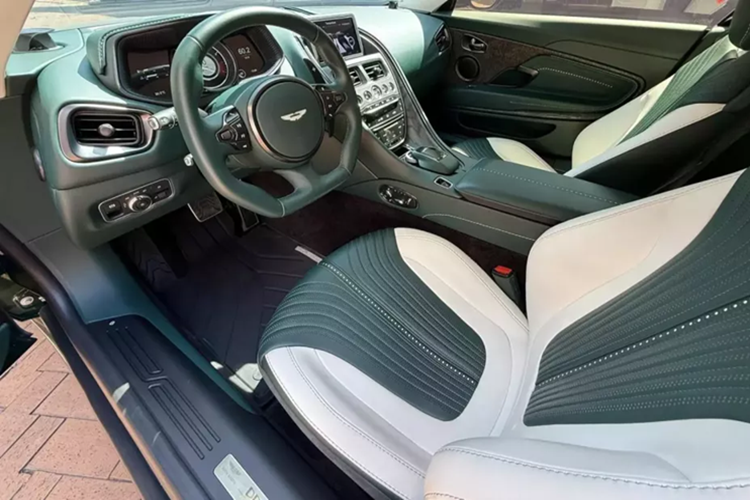 Khi cánh cửa chim 45 độ của xe Aston Martin DB11 V8 được mở ra sẽ khiến khách hàng choáng ngợp trước các vật liệu cao cấp như da đắt tiền, nhôm và cả sợi carbon. Chiếc xe Aston Martin DB11 V8 này phối 2 màu nội thất là xanh và trắng. Bảng điều khiển trung tâm ngoài bọc da còn có thêm sợi carbon nhám.