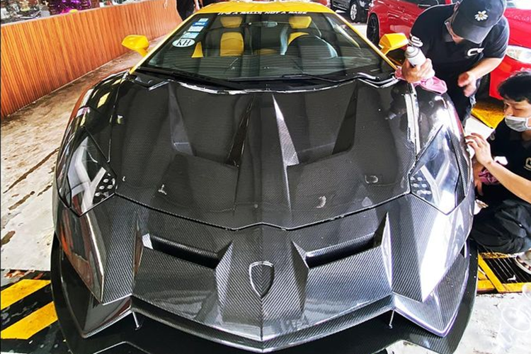 Đó chính là phần hốc gió bên hông có thanh chia gió đặt xéo cá tính, ngoài ra đó là cản va trước chia thành 2 phần nhờ chủ xe tích hợp thêm cánh lướt gió mới đầy hầm hố. Nắp capô mới thực sự là điểm nhấn ở thiết kế đầu xe bản độ Lamborghini Aventador Duke Dynamics, chi tiết này hoàn toàn từ sợi carbon.