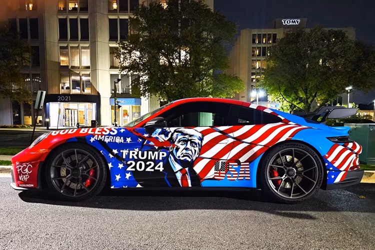 Chiếc Porsche 911 GT3 sở hữu màu sơn gốc xanh Shark Blue quen thuộc, kết hợp với hình ảnh ông Trump giơ cao nắm đấm sau vụ ám sát tại Pennsylvania vào tháng 7/2024.