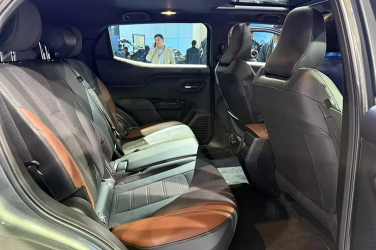 Suzuki e Vitara 2025 được trang bị cụm đèn pha cỡ lớn, tích hợp 3 dải đèn LED định vị ban ngày và hốc gió trung tâm rộng trên cản trước. Thêm vào đó là đèn sương mù tích hợp vào cản trước, hốc bánh khỏe khoắn, tay nắm cửa sau nằm trên cột C, nóc dốc dần về phía sau và ăng tay vây cá trên nóc. Phía sau xe xuất hiện cụm đèn hậu nối liền hai bên và cửa cốp thẳng đứng.