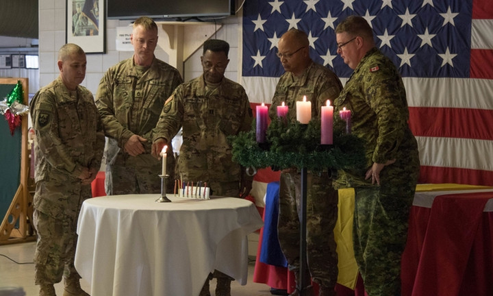 Binh sĩ Mỹ và Canada thắp nến trong buổi lễ trước Giáng sinh tại căn cứ không quân Mihail Kogălniceanu, Rumani ngày 6/12. Ảnh: US Army