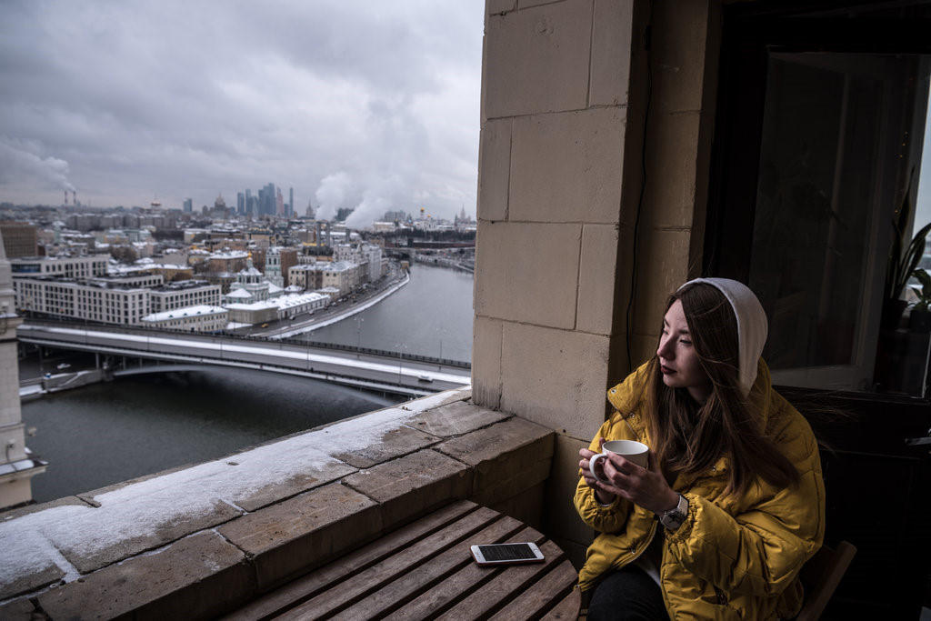 Yulia Abramova, một nhà thiết kế, ngồi trên ban công trong căn hộ của cô ở tòa tháp Kotelnicheskaya, tòa dân cư cao tầng duy nhất từng được cải tạo. Những năm 1990, giới thượng lưu được trao đặc quyền ở miễn phí trong các căn hộ cao tầng này. Sự hào nhoáng của các cửa hàng tạp hóa tại đây với sàn và cột đá cẩm thạch, trần nhà cao với đèn chùm tinh xảo, cửa sổ kính màu cùng đầy ắp sữa, xúc xích, sô cô la và trứng cá muối đựng trong bát pha lê, từng khiến người dân thủ đô lóa mắt.
