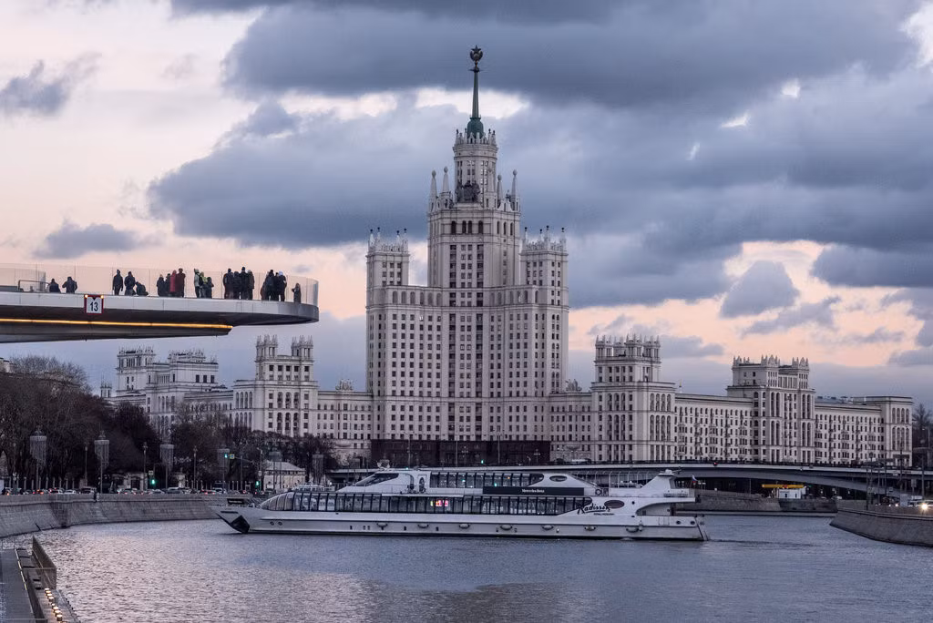 Khách du lịch đứng trên cây cầu phía trước tòa nhà Kotelnicheskaya Embankment. Một số người cảm thấy những tòa nhà này thật tráng lệ, số khác cho rằng chúng kỳ lạ và nặng nề.