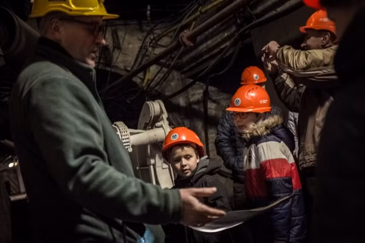 Irek, từng làm thợ mỏ trước khi chuyển sang làm hướng dẫn viên du lịch, đang dẫn một nhóm trẻ em thăm quan khu hầm sâu Guido ở Zabrze, Silesia.