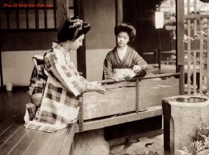 Hai người phụ nữ Nhật Bản mặc kimono, búi tóc cao cùng lối trang điểm truyền thống xuất hiện bên phía ngoài nhà. Ảnh QQ.