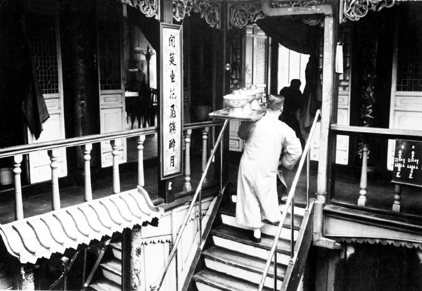 Anh bồi bàn đang bưng bê đồ phục vụ khách trong một hàng ăn. Còn ở phía ngoài cửa hàng ăn, ông chủ thường đứng ở đó để chào mời khách. Ảnh ILS.