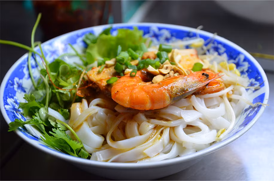 Tô mì Quảng ở chợ Hội An rấp hấp dẫn với con tôm to bự. "Tôi phát hiện ra rằng mì của Hội An thậm chí còn ngon hơn so với Đà Nẵng - những món mì này được phục vụ với tôm và thịt lợn trong một nước dùng đầy vị ngọt tự nhiên của hải sản" - James. Ảnh: Plus Ultra.