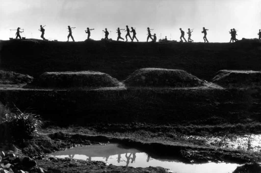 Các chiến sĩ Quân đội Nhân đân Việt Nam và nông dân gánh giỏ đất để sửa một con đê bị không quân Mỹ ném bom ở miền Bắc Việt Nam năm 1969. Ảnh: Marc Riboud/ Magnum.