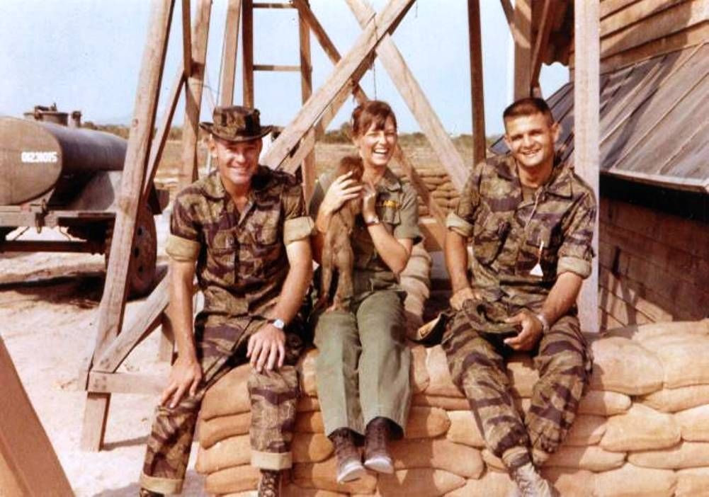  Nữ y tá ôm chú khỉ khi ngồi giữa hai binh sĩ Mỹ tại một căn cứ quân sự ở Việt Nam năm 1965. Ảnh: Pinterest. 