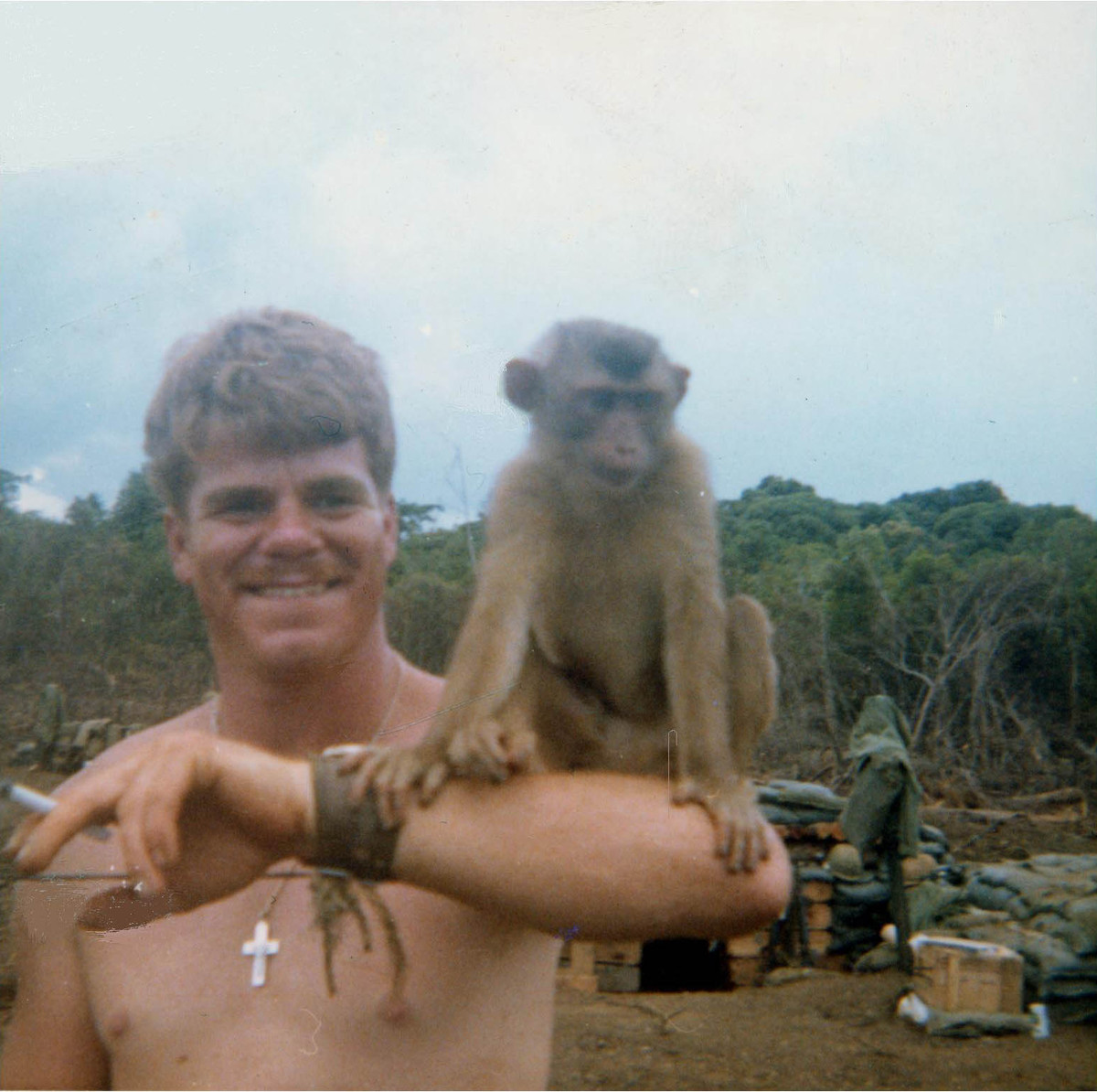  Chú khỉ chồm hỗm trên cánh tay người lính Mỹ tên Dwight Davis tại một đơn vị pháo binh Mỹ thời chiến tranh Việt Nam. Ảnh: Shakenbakesergeant.com. 