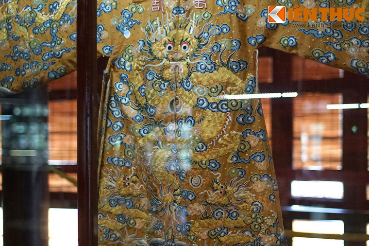 Đây là một tấm áo rất lộng lẫy, được chế tác hết sức công phu. Tính chất đế vương được thể hiện qua chất liệu gấm, lụa vàng óng cùng hình tượng rồng vờn mây.