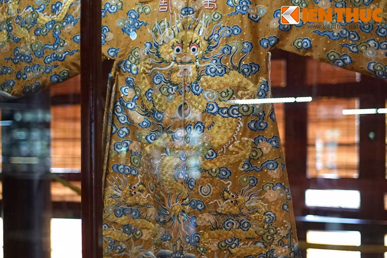 Đây là một tấm áo rất lộng lẫy, được chế tác hết sức công phu. Tính chất đế vương được thể hiện qua chất liệu gấm, lụa vàng óng cùng hình tượng rồng vờn mây.