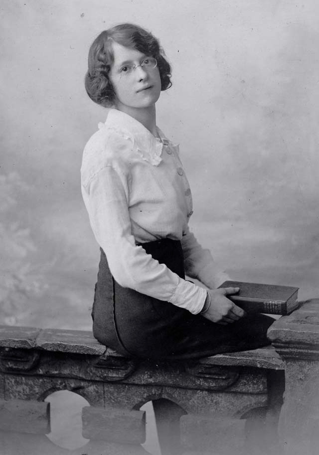 Nét quyến rũ mang màu sắc bác học của một cô gái đeo kính, tay cầm quyển sách dày cộp.