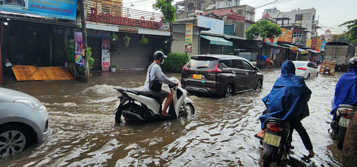 Nhiều xe máy tìm đường thoát vùng ngập nước.