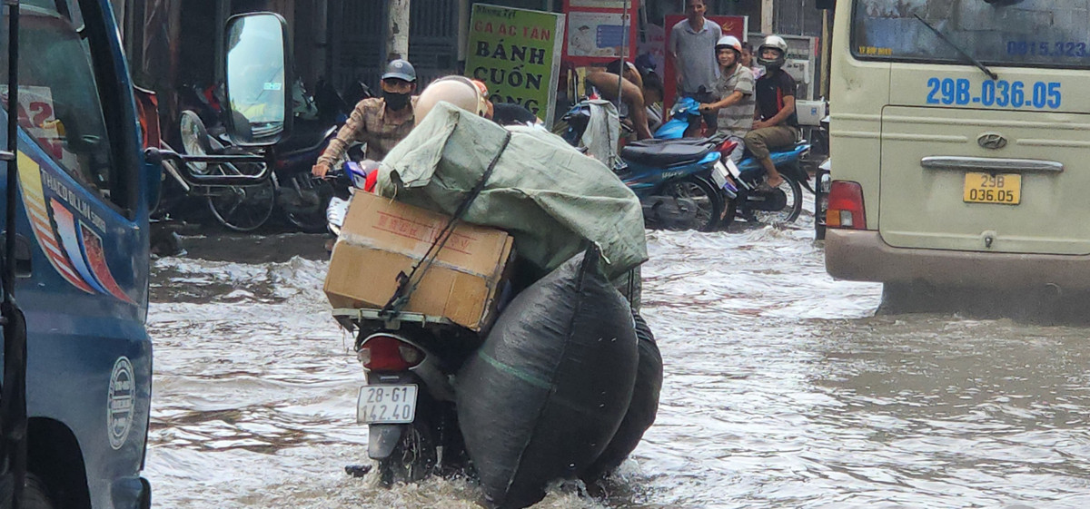 Hàng hóa chở trên xe máy cũng bị thấm ướt.
