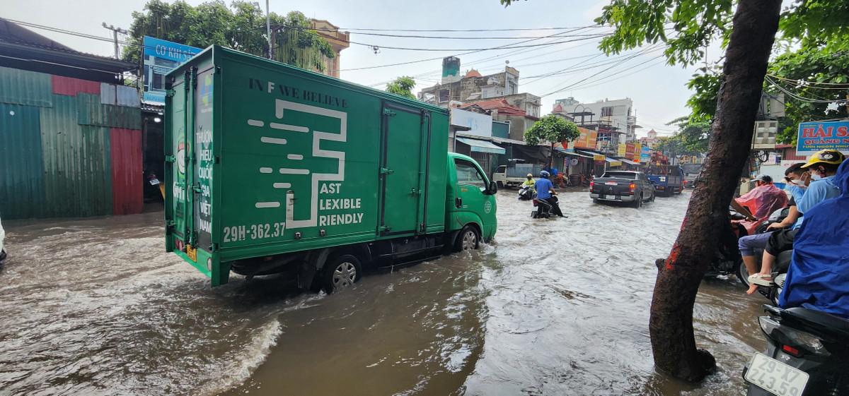 Các xe tải lớn tạo nhiều cơn sóng nước, đánh mạnh vào 2 bên vỉa hè.