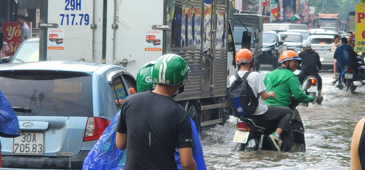 Những chuyến xe grab cũng chôn bánh giữa vùng nước ngập.