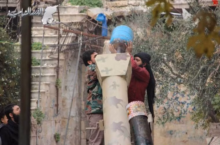 Quân nổi dậy Syria đang nạp đạn pháo tự chế làm từ bình ga vào một nòng súng lớn chưa từng thấy.