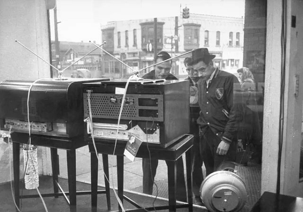 Những người đàn ông tập trung trước một cửa tiệm ở bang Pennsylvania để xem chương trình truyền hình đang phát trên những chiếc tivi hàng mẫu năm 1948.