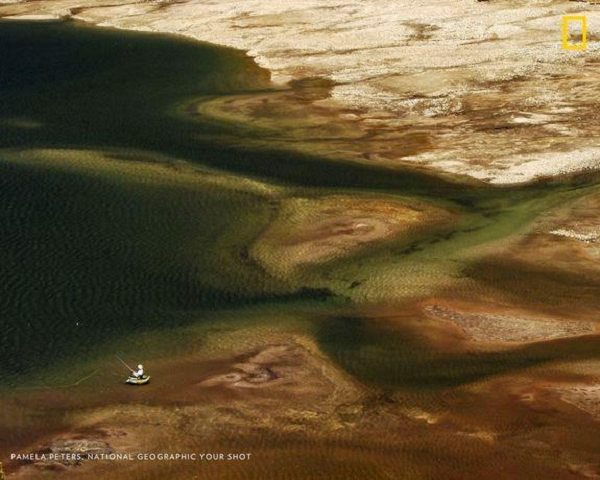Một người đàn ông đánh bắt cá trong hồ bị ảnh hưởng bởi hạn hán ở Sierra Nevada Mountains, California, Mỹ.