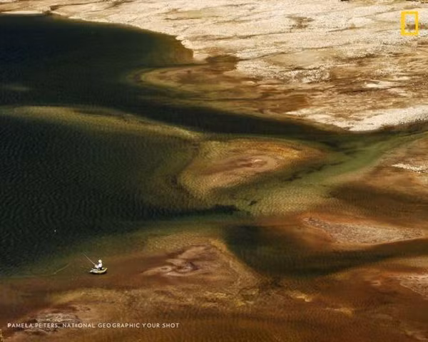 Một người đàn ông đánh bắt cá trong hồ bị ảnh hưởng bởi hạn hán ở Sierra Nevada Mountains, California, Mỹ.