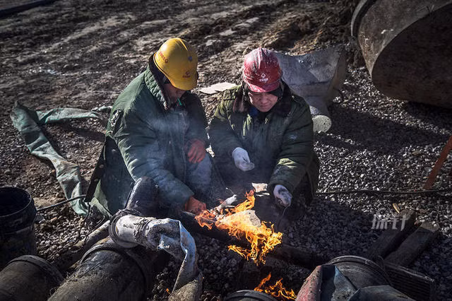 Công nhân xây dựng đường ống nước phải dùng lửa để đốt nóng một đường ống bị đóng băng.