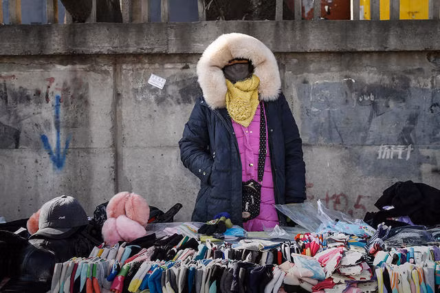 Cô Yang Nushi che kín mặt trong khi bán hàng tạp hóa trên đường phố.