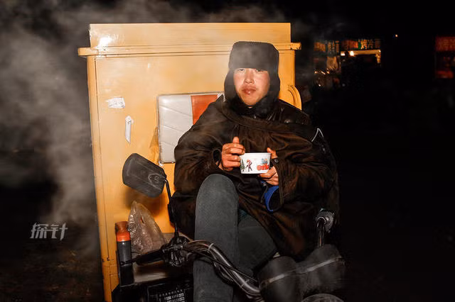 Wang Kai, làm nghệ vận chuyển hàng hóa, tranh thủ ăn tối trong khi vẫn đang ngồi trên xe.